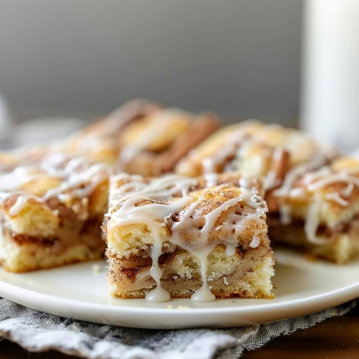 Cinnamon roll cake slices with vanilla glaze on a plate