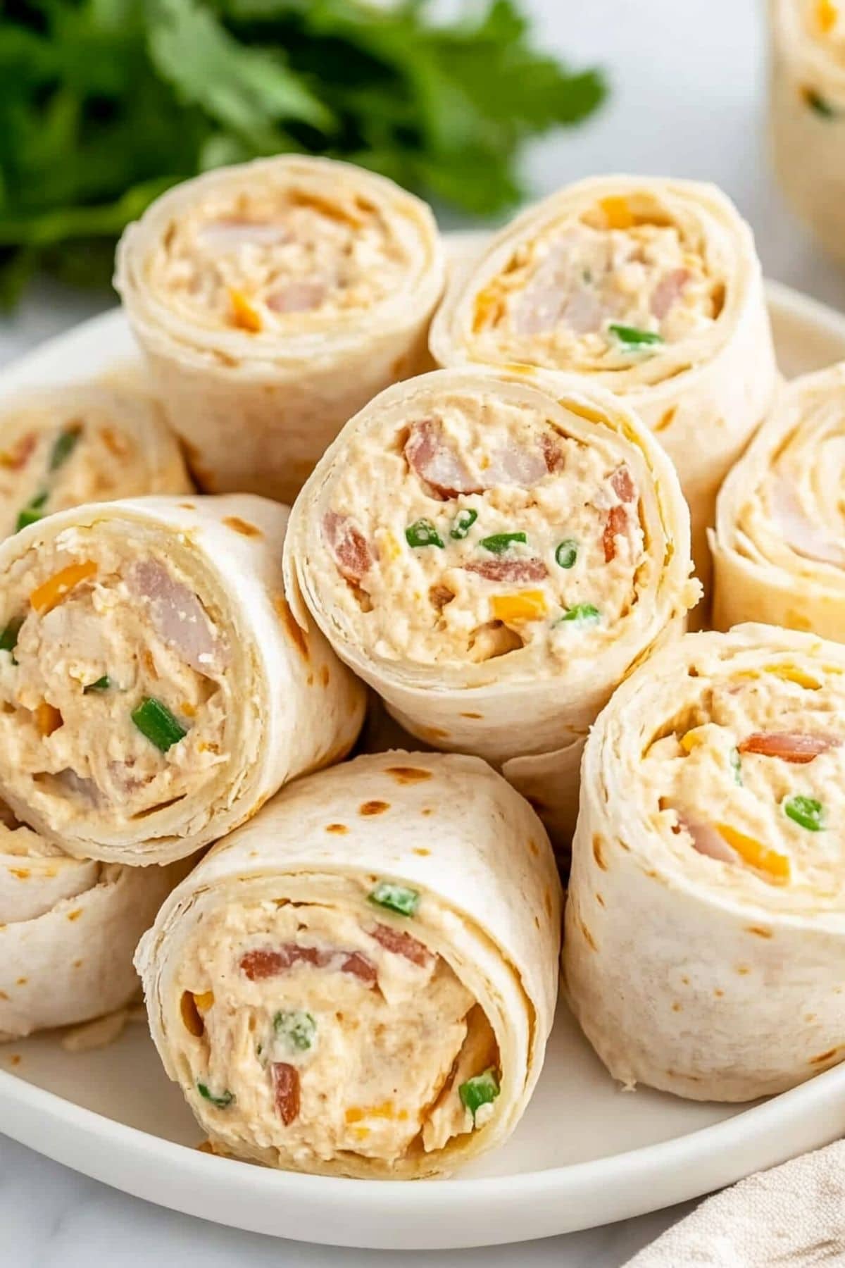 Bunch of sliced chicken pin wheels in a white plate. 