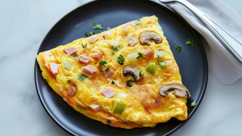 A Denver omelette with slight crispy edges and gooey cheese filling.