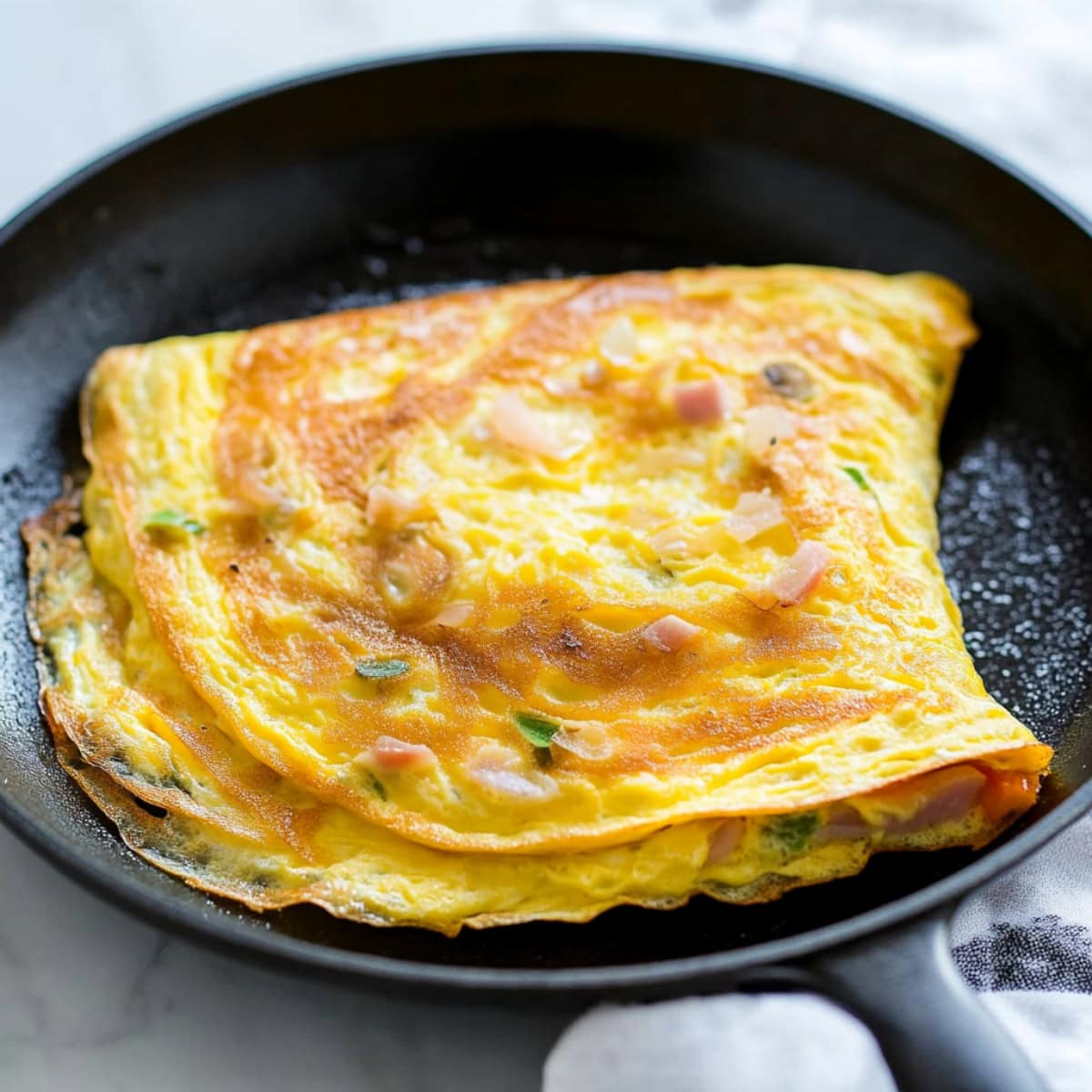 A hearty Denver omelette in a skillet garnished with fresh parsley.