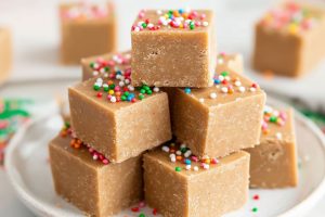 Bunch of cube slices of gingerbread fudge arranged in a white plate.