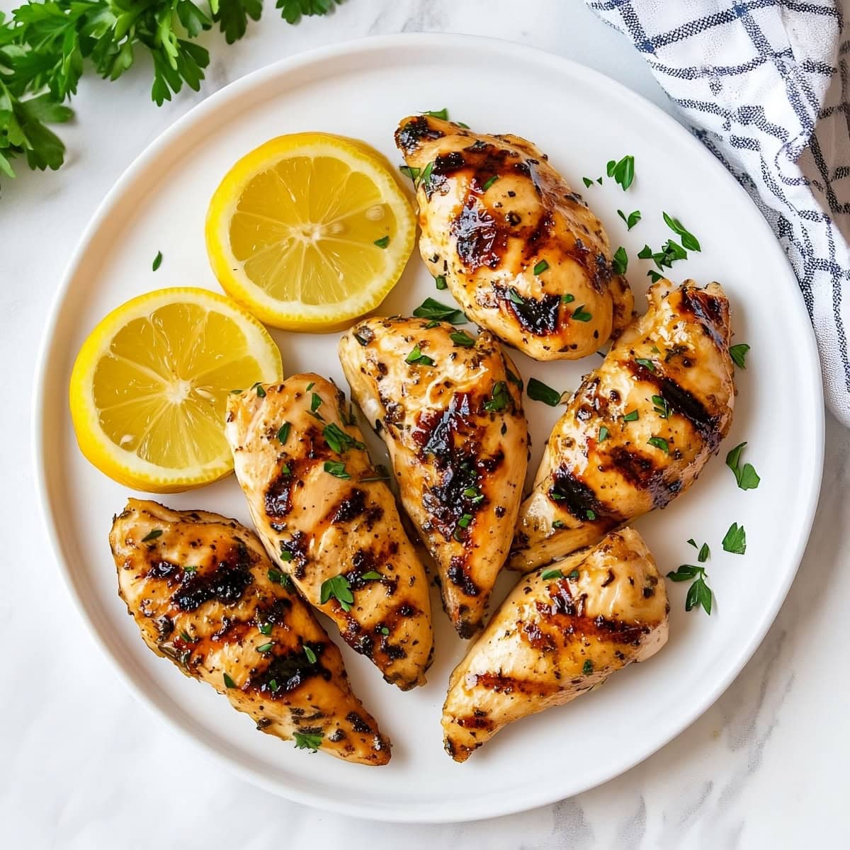 Golden-Brown chicken tenders in a white plate, top view.