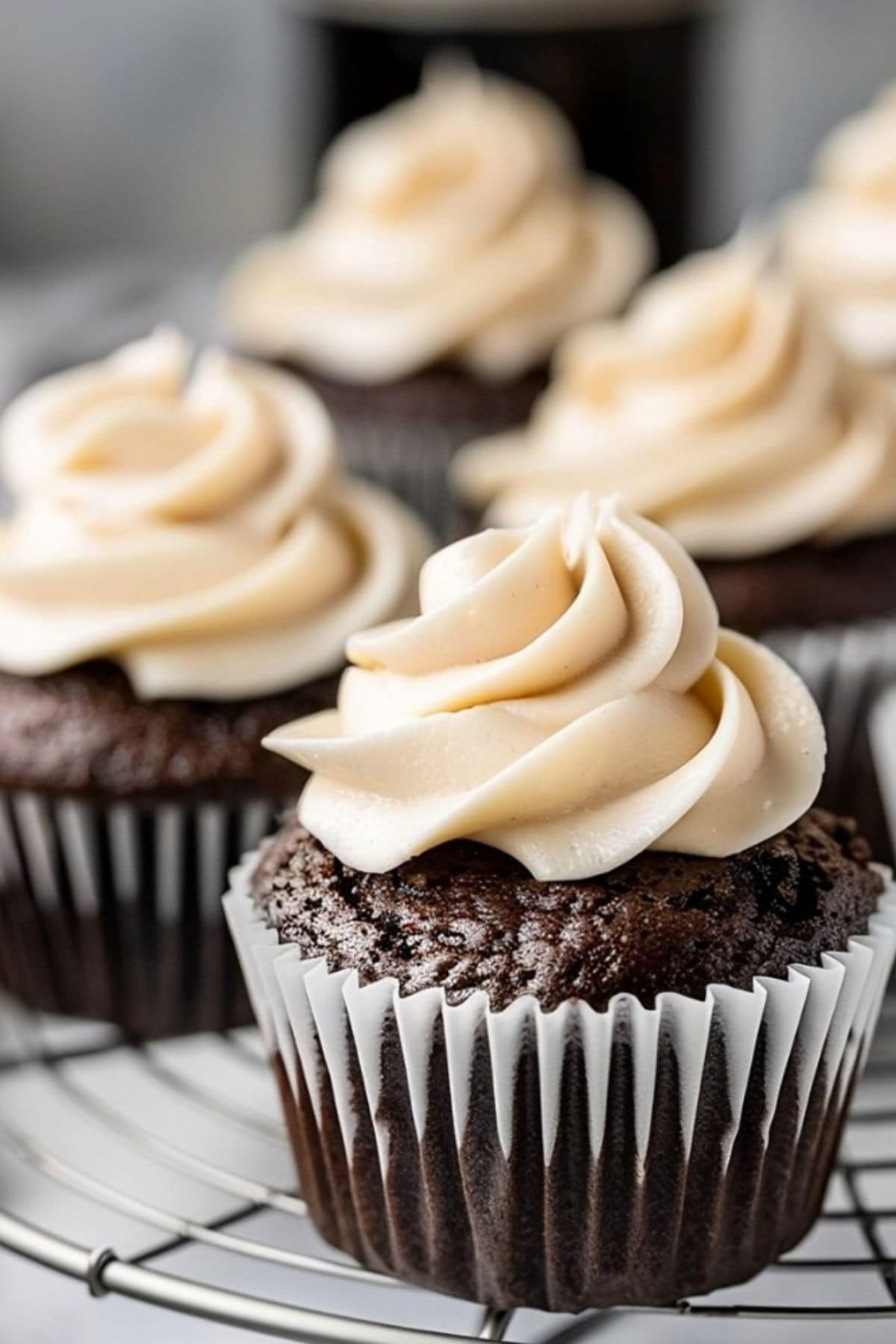 Guinness chocolate cupcakes with Irish cream frosting arranged on a cooling rack.