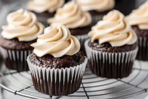 Bunch of chocolate cupcake garnished with whipped cream arranged in a cooling rack.