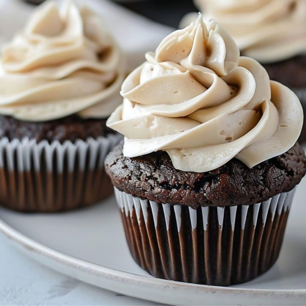 Guinness Chocolate Cupcakes topped with Irish Cream Frosting served on a white plate, close up