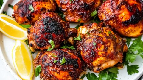 Harissa honey chicken served in a white plate.