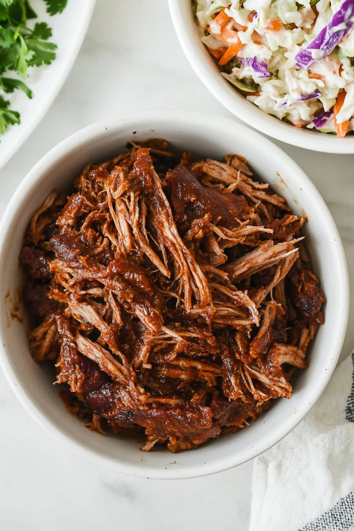 Bowl of shredded pork barbeque and coleslaw.