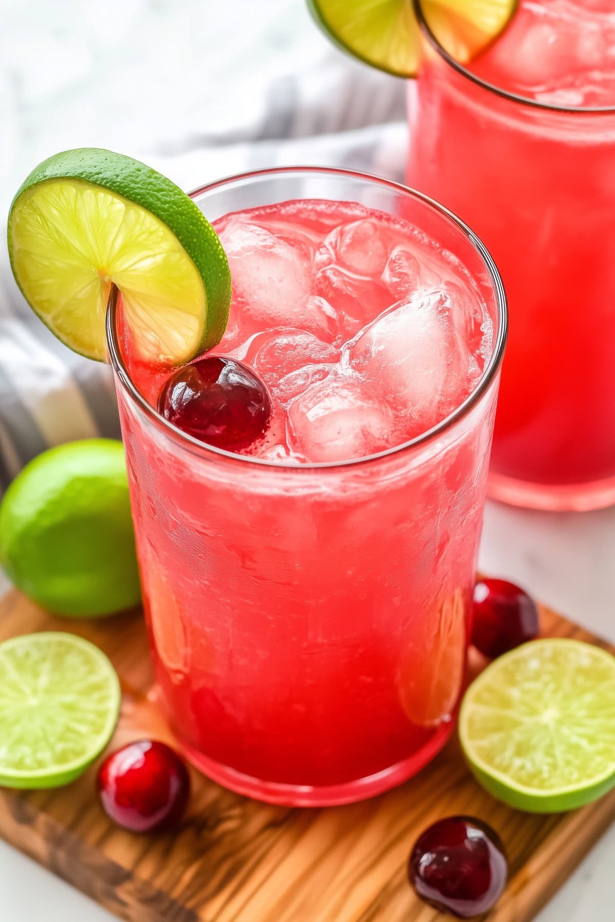 Sweet and refreshing cherry limeade in a tall glass with lime slices and cherries as garnish