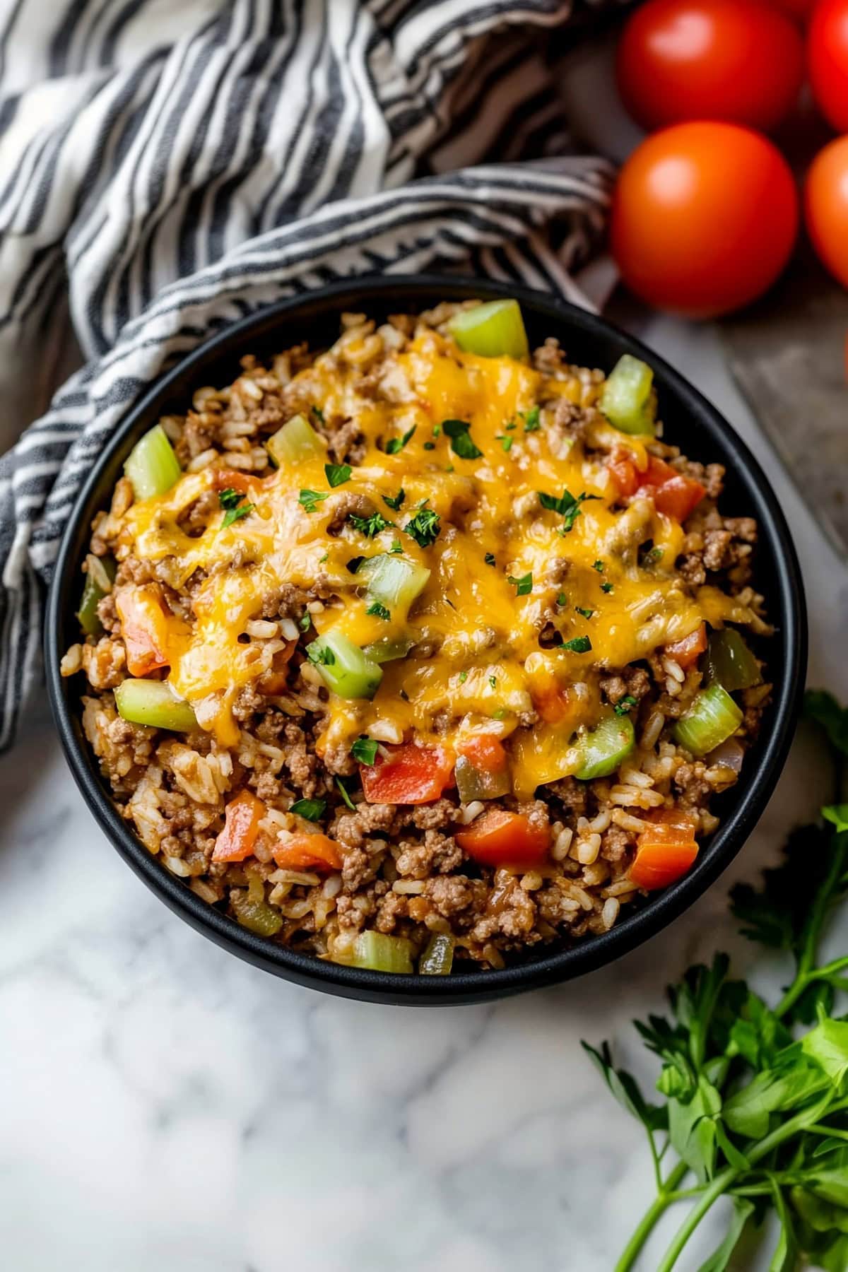 Cheesy Texas hash with rice, ground beef, tomatoes, celery and green bell peppers.