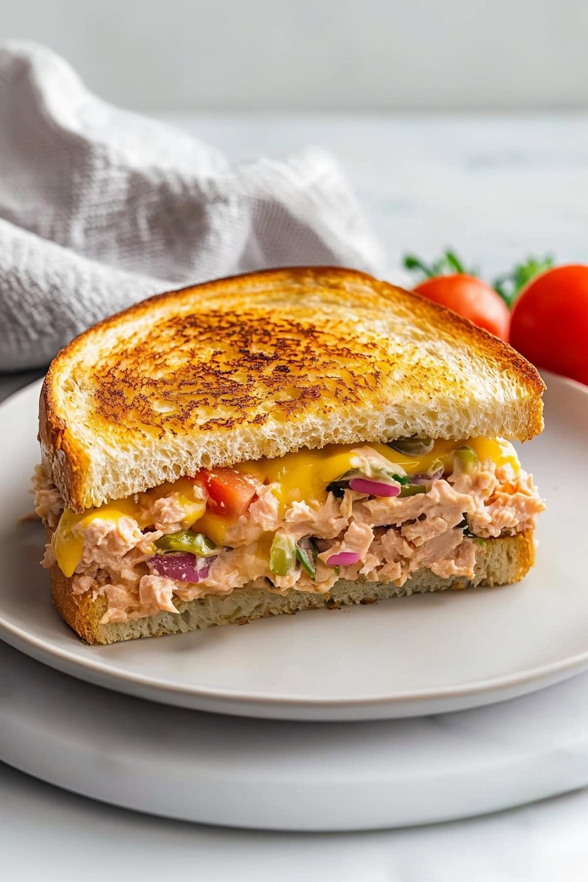 Homemade tuna melt with tomatoes, onions and relish pickles.