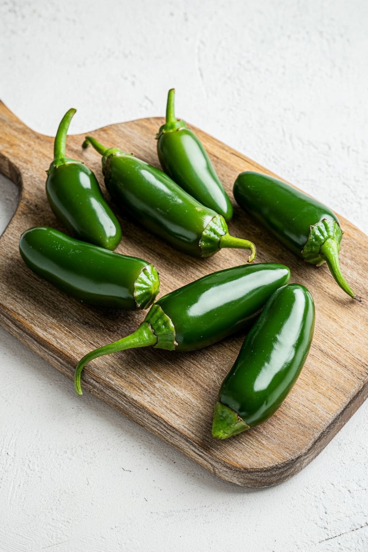 Fresh jalapenos in a wooden board.