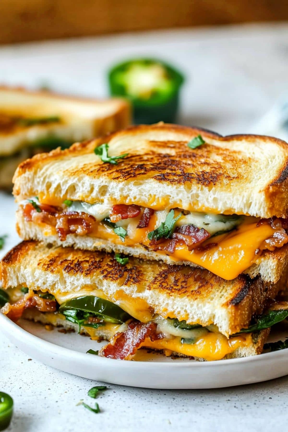 Cheesy jalapeno popper grilled cheese sandwich served in a white plate.