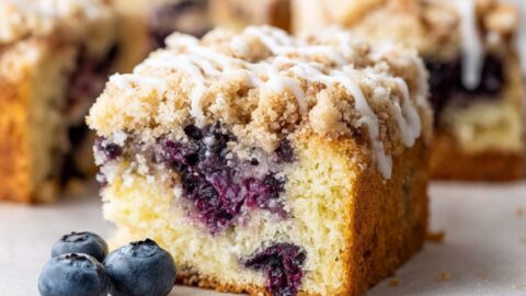 A close-up of lemon blueberry coffee cake drizzled with vanilla icing.