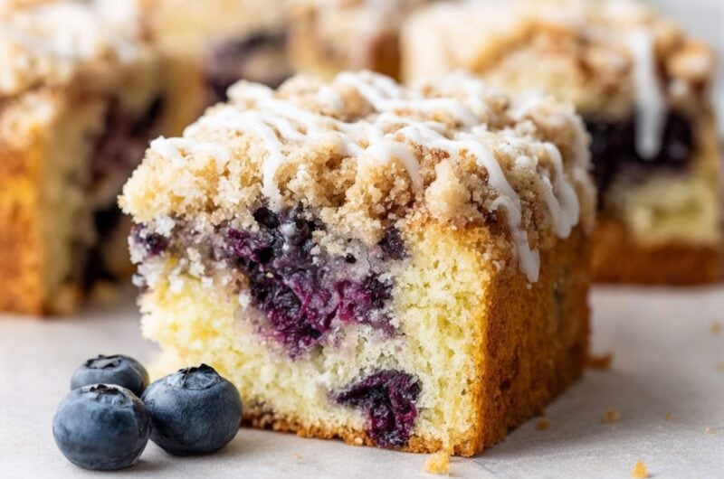 A close-up of lemon blueberry coffee cake drizzled with vanilla icing.