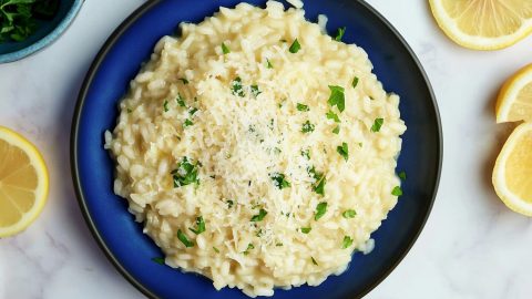 Overhead shot of lemon risotto with flecks of fresh herbs