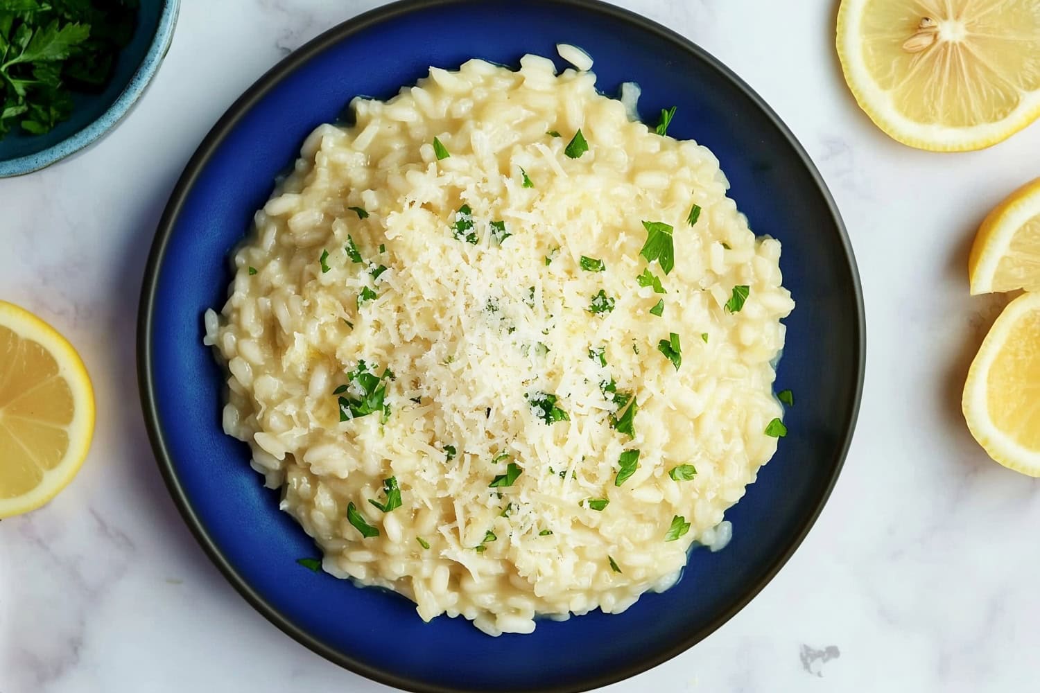 Overhead shot of lemon risotto with flecks of fresh herbs