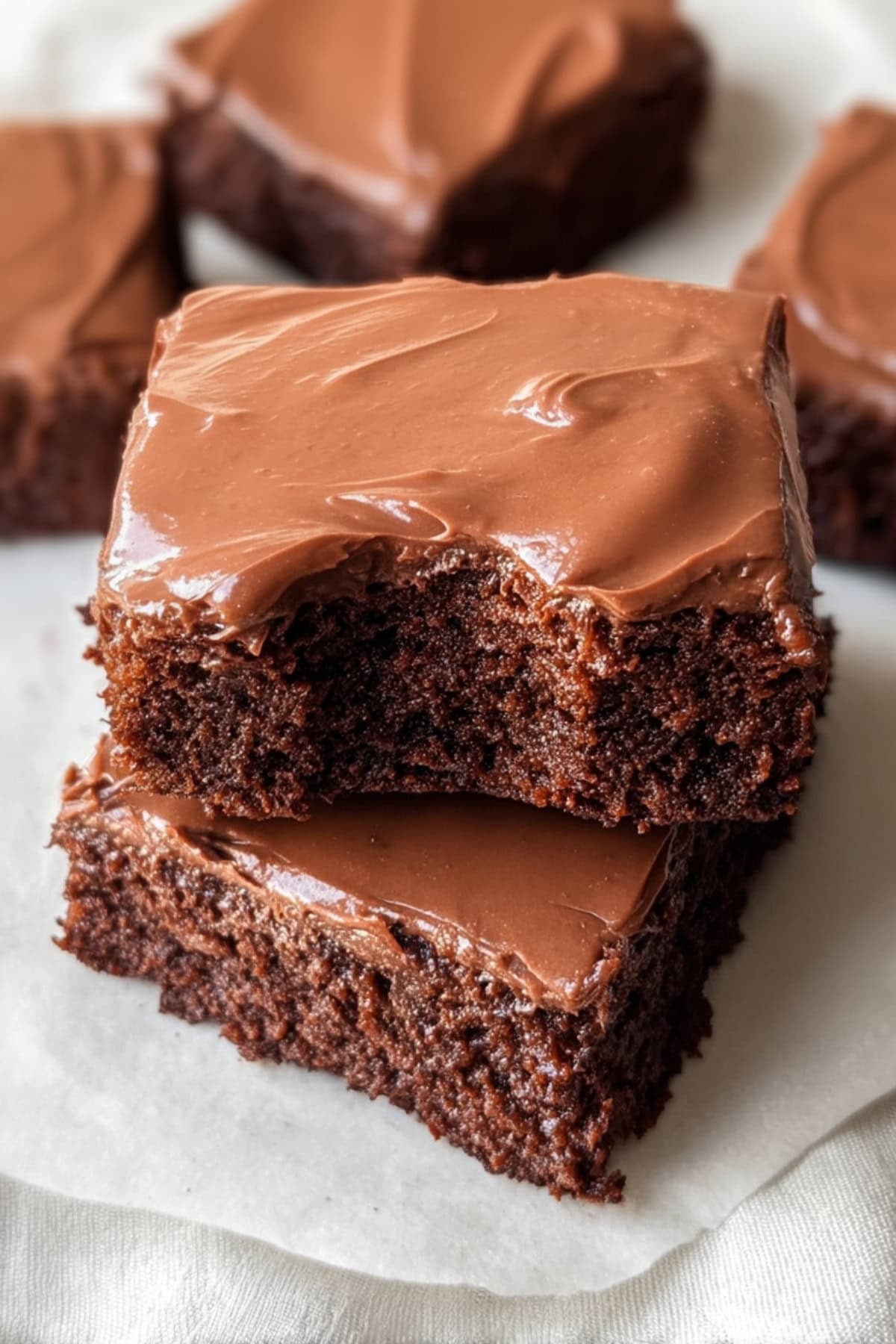 Stacked Lunch Lady brownies with chocolate frosting topping.
