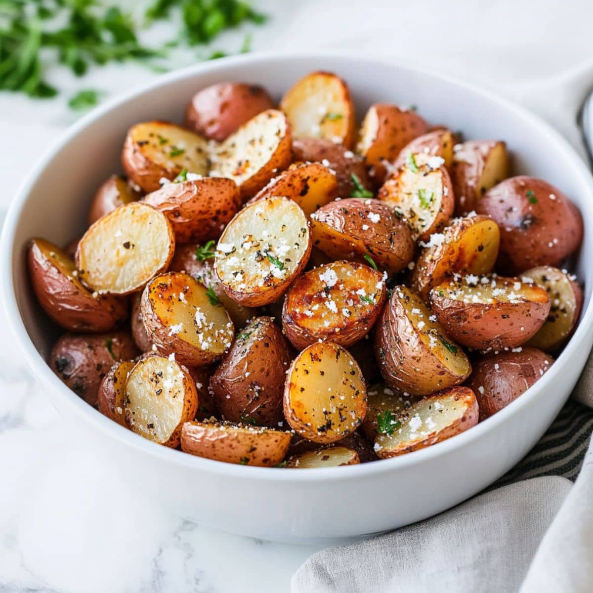 Oven roasted baby red potatoes in a white bowl.