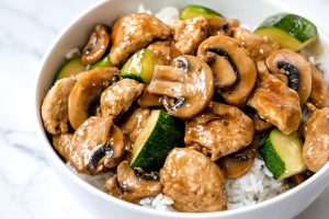 Panda express mushroom chicken served in a white bowl with white rice.