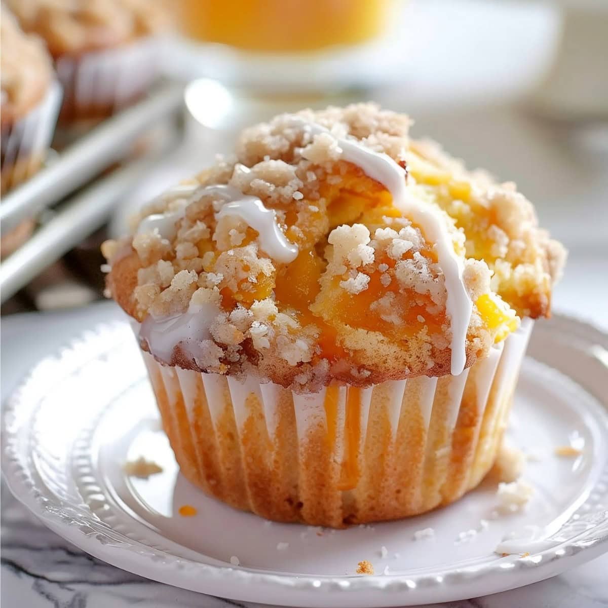 Peach Crumb Muffin with sweet glaze on a plate, close up