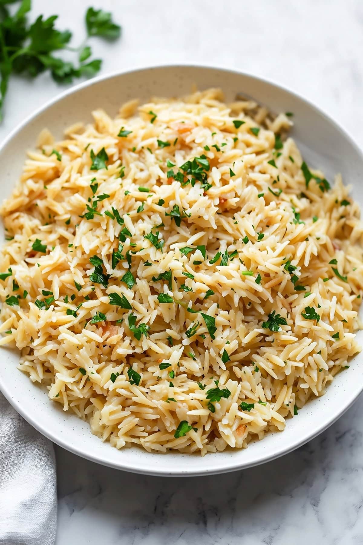 Homemade rice pilaf with orzo pasta, garnished with parsley.