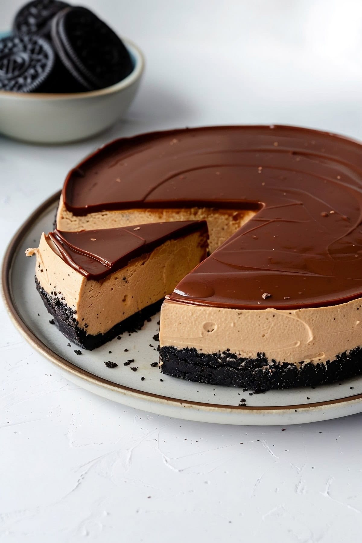 Peanut Butter Cheesecake with Oreo Crust on a serving plate with a slice cut out