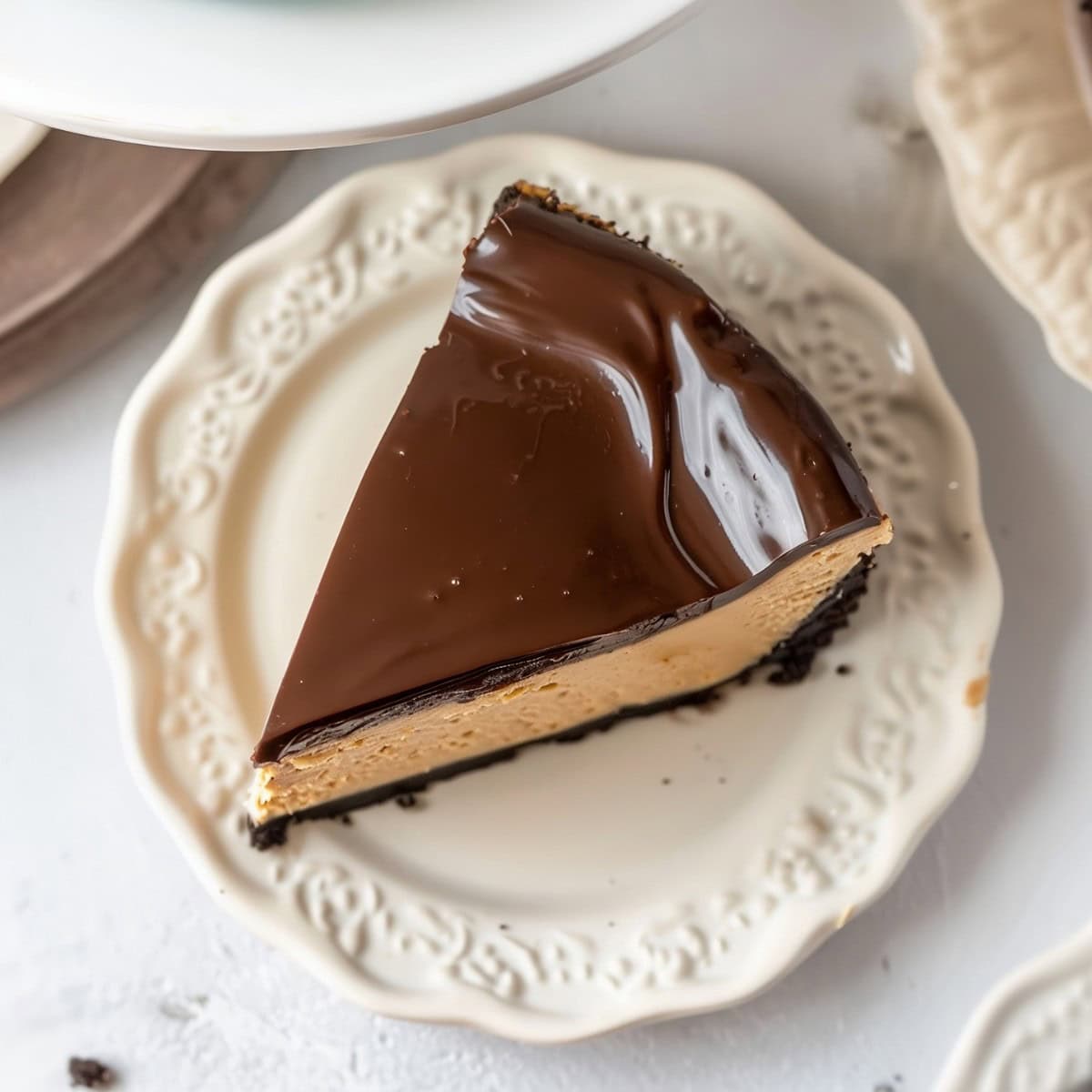 Rich peanut butter cheesecake with a smooth, velvety texture and shiny ganache topping, top view.