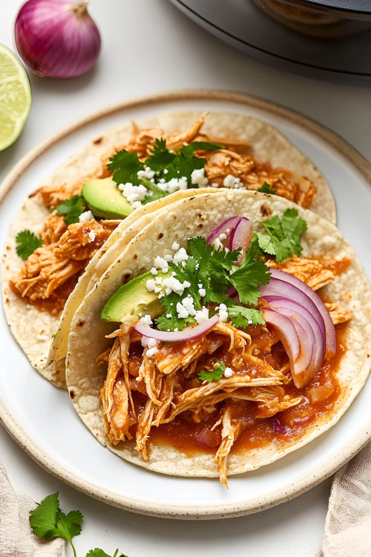 Tortillas with shredded chicken, avocado slices, onions and cheese filling.