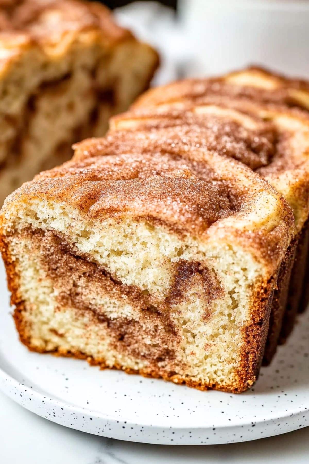 Sliced snickerdoodle bread on a white plate.