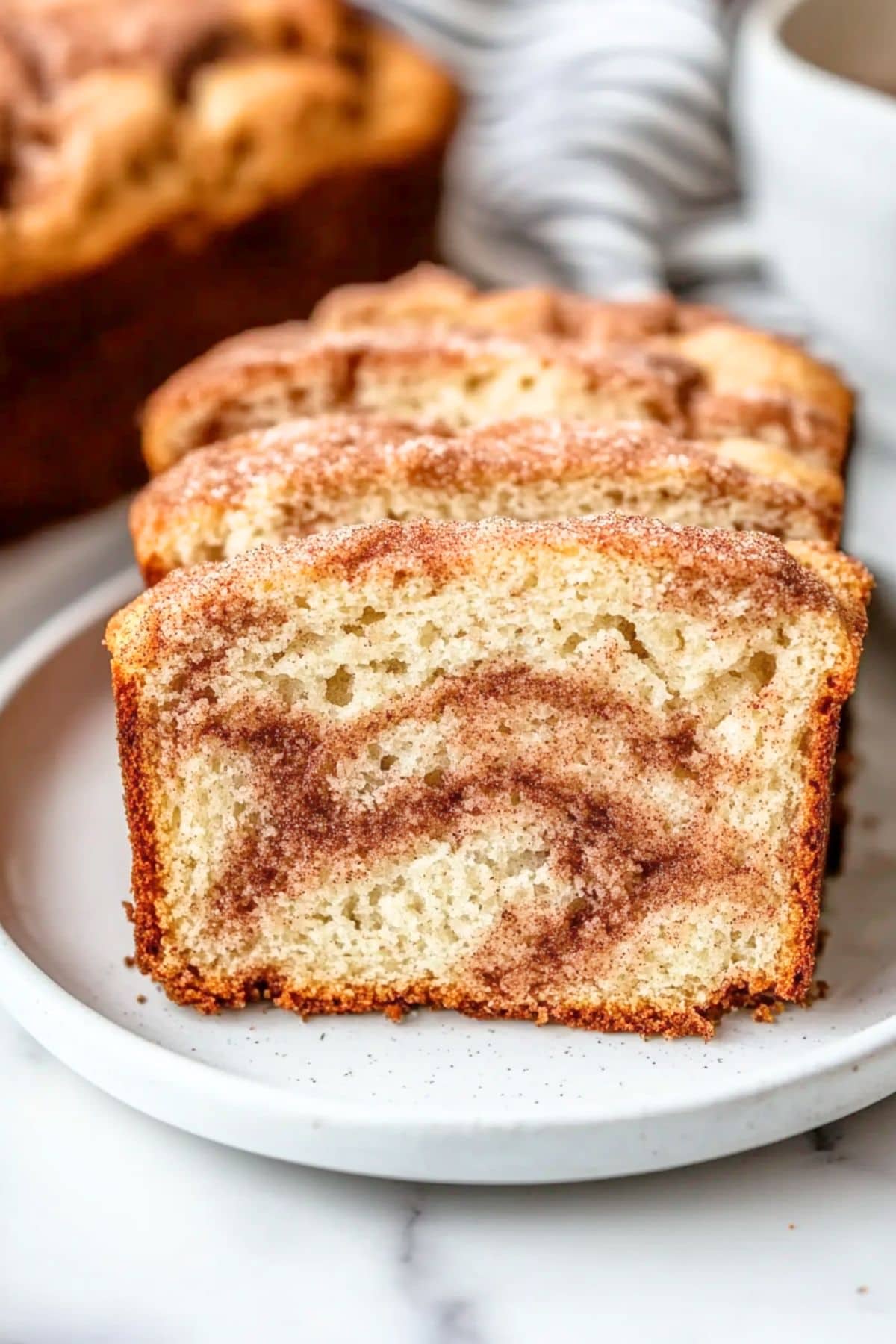 Slices of snickerdoodle bread served on a white plate.