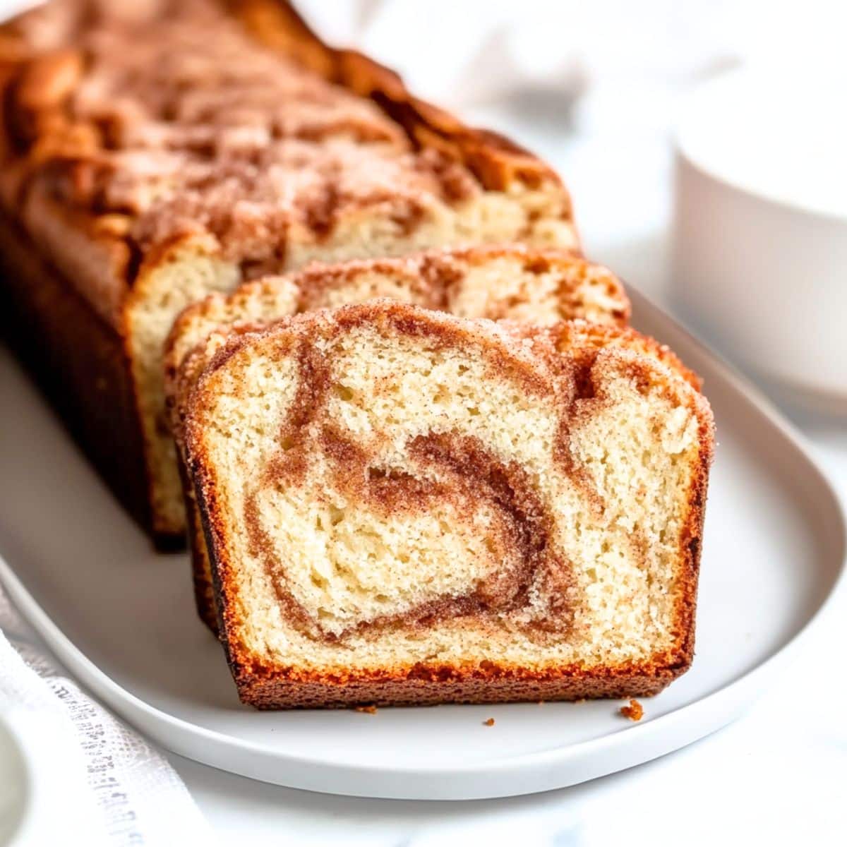 Slices of snickerdoodle bread served on a white plate.