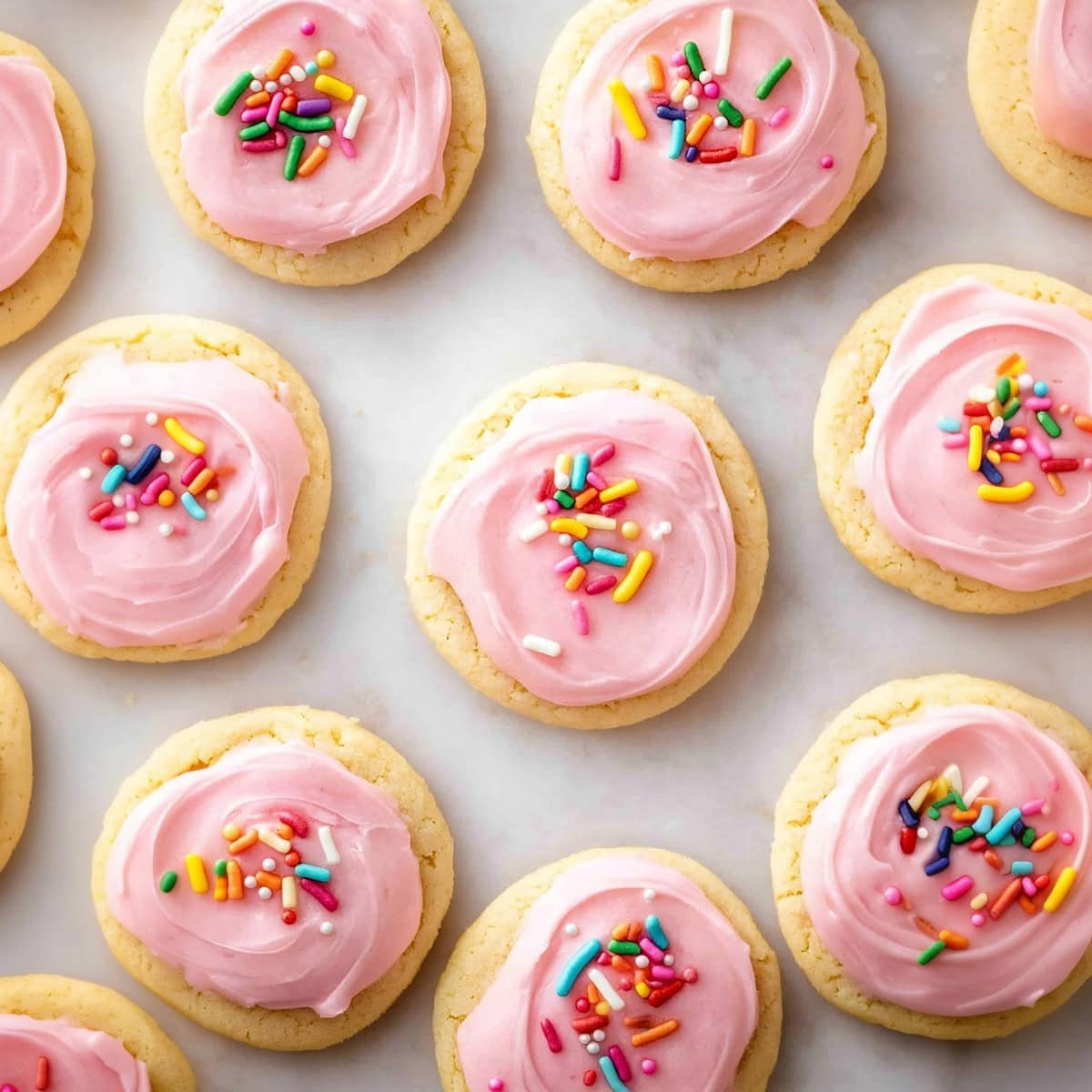 Frosted sugar cookies decorated with  sprinkles, top view.