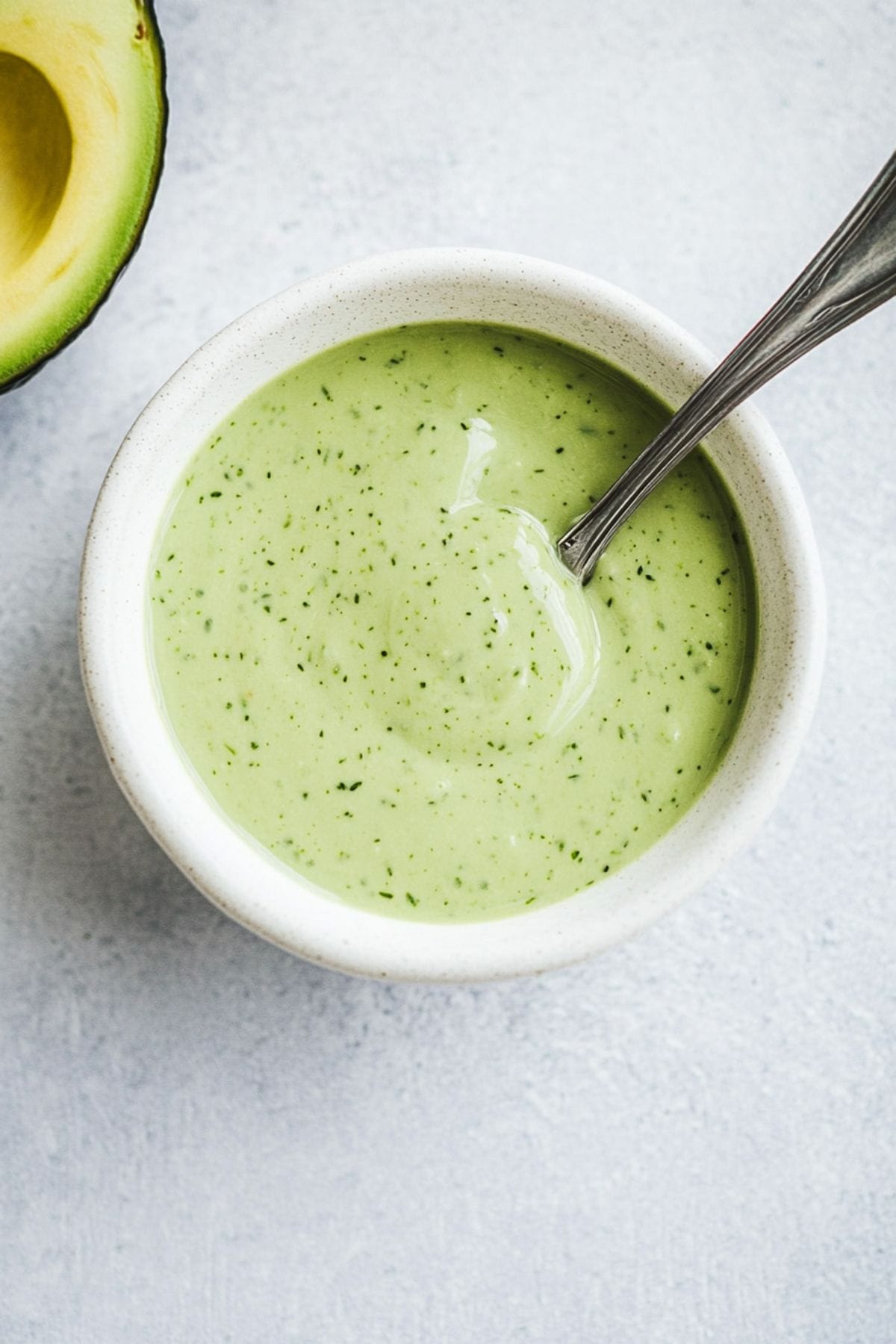 Avocado dressing in a white bowl.