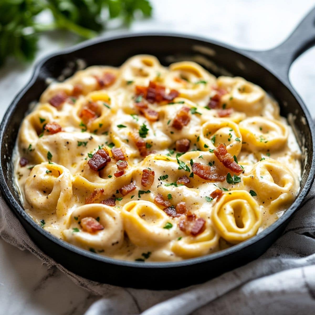 Tortellini carbonara in a cast iron skillet pan.