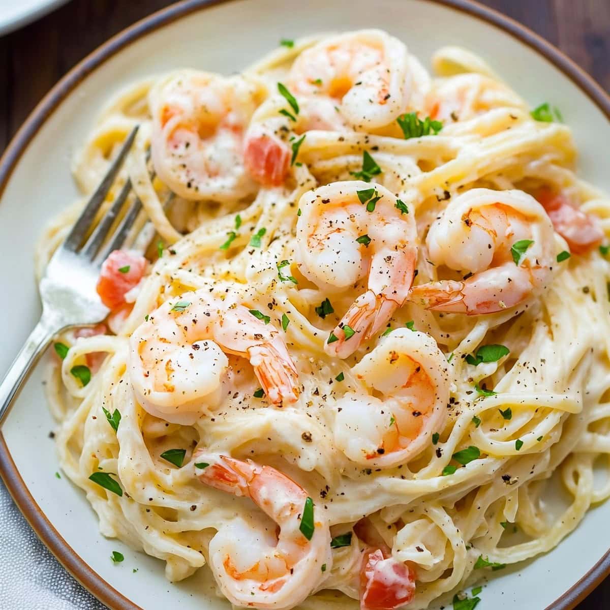 Angel hair pasta with shrimp served in a plate with fork. 