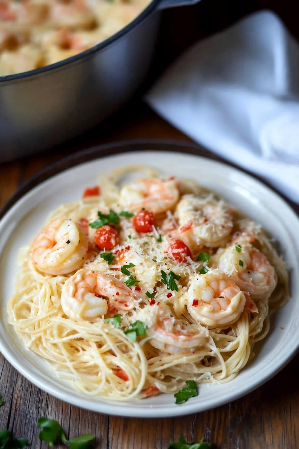 Angel hair pasta with creamy sauce and shrimp served in a plate.