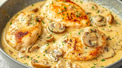 Creamy chicken Diane with mushrooms and herbs served on a skillet.