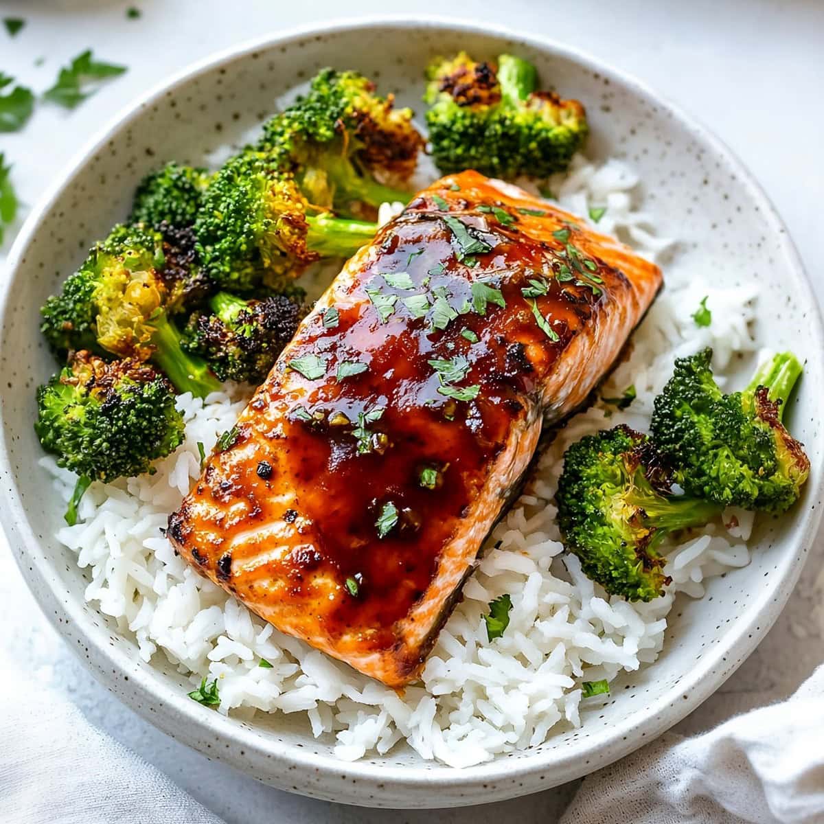 Sweet and spicy firecracker salmon with rice and cooked broccoli, top view.