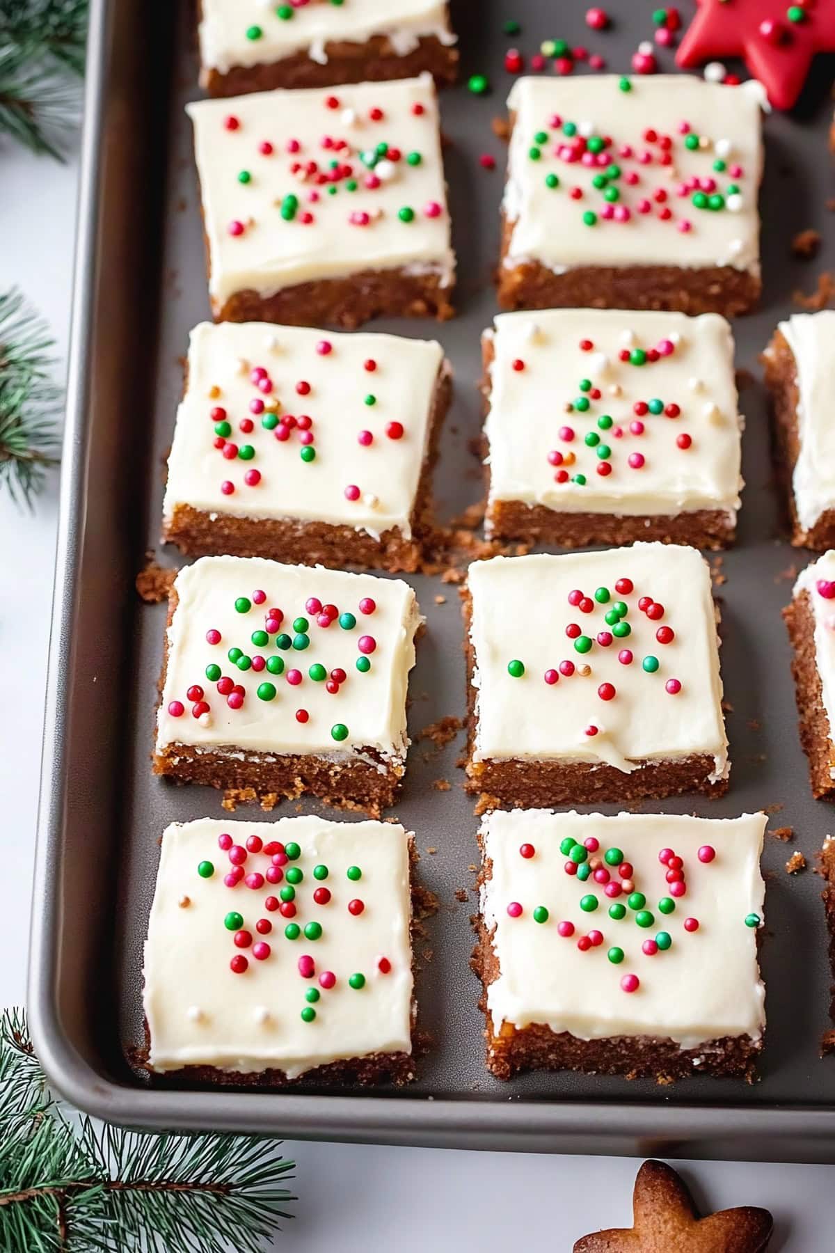 Gingerbread bars with cream cheese frosting sliced in a sheet tray.