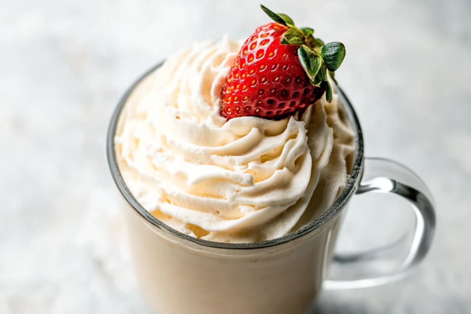 Mug of Baileys whipped cream with fresh strawberry on top.