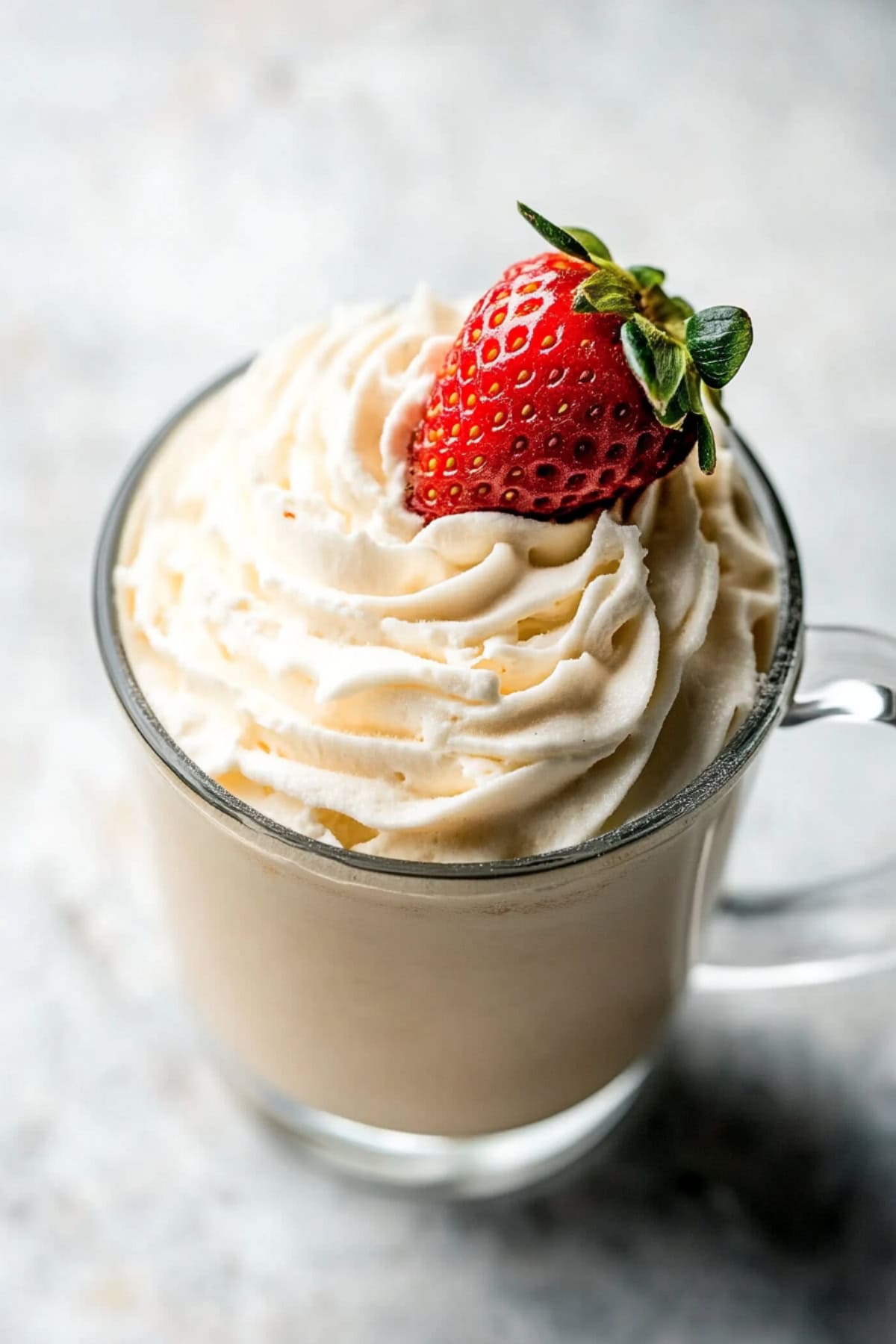 Baileys whipped cream in a mug with fresh strawberry.