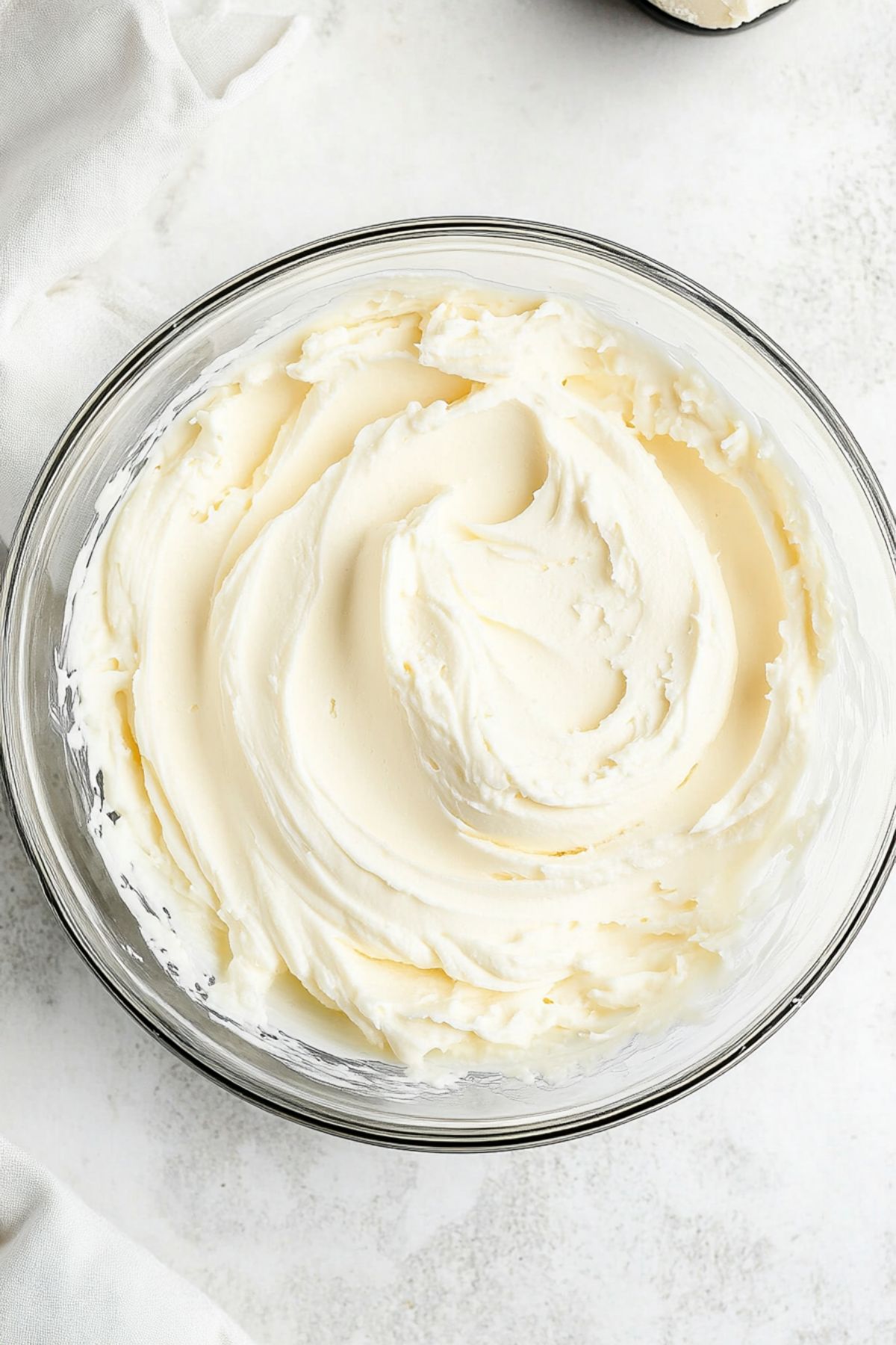 Whipped cream in a glass bowl, top view