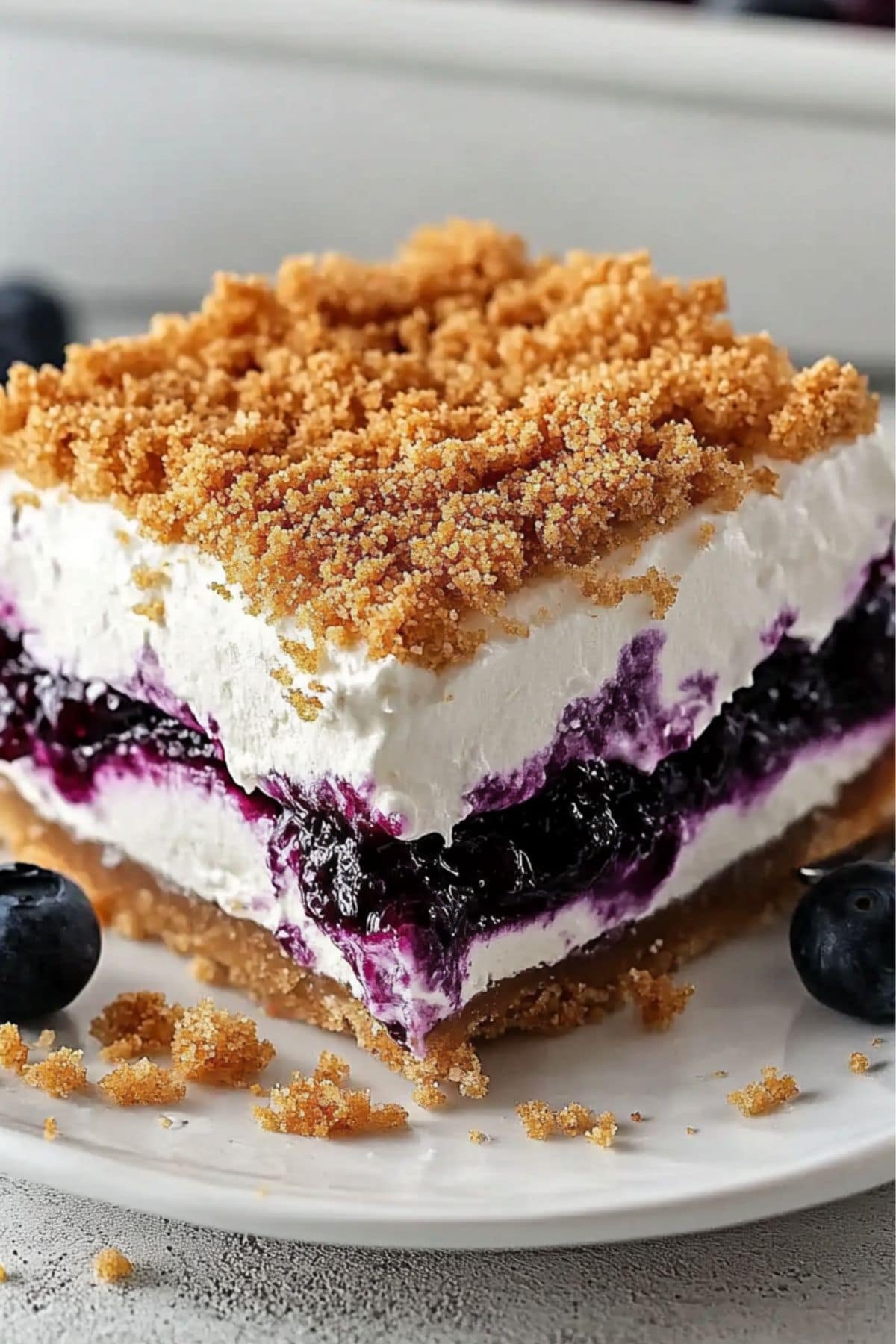 A serving of blueberry yum yum made with layers of thick whipped cream with blueberry filling, close up