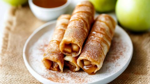 Caramel apple taquitos served with a dipping sauce.