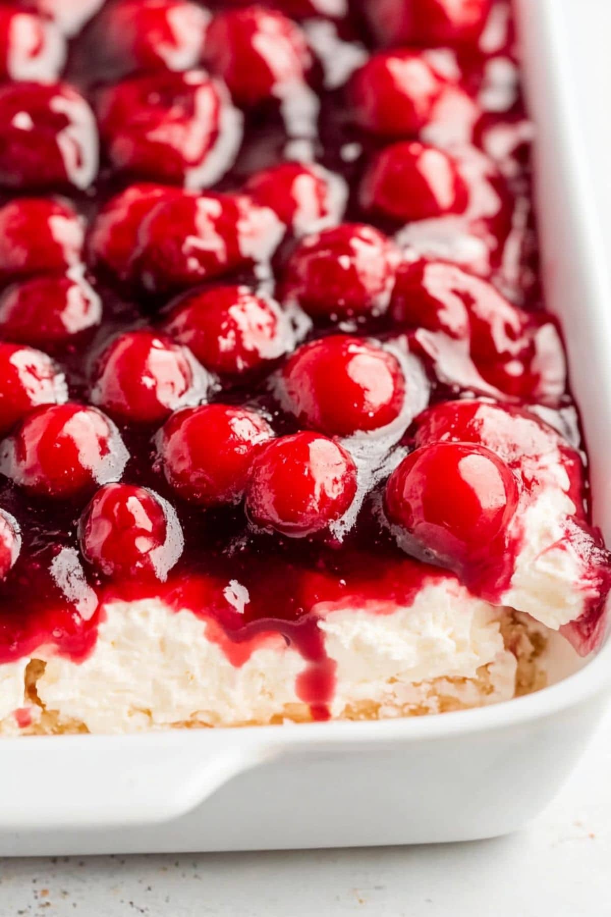 Cherries in the snow in a white rectangular baking dish.