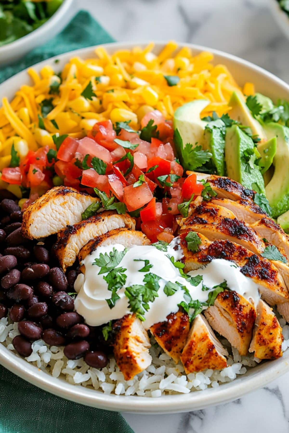 Chicken burrito in a white bowl made with black beans, sweet roasted corn, and fresh pico de gallo.