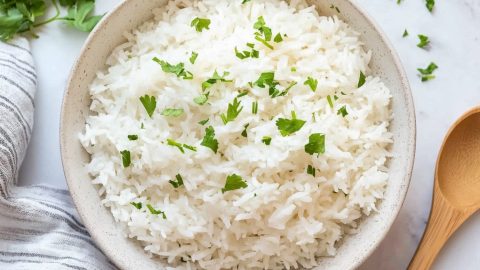 An overhead view of coconut rice sprinkled with chopped parsley for garnish.