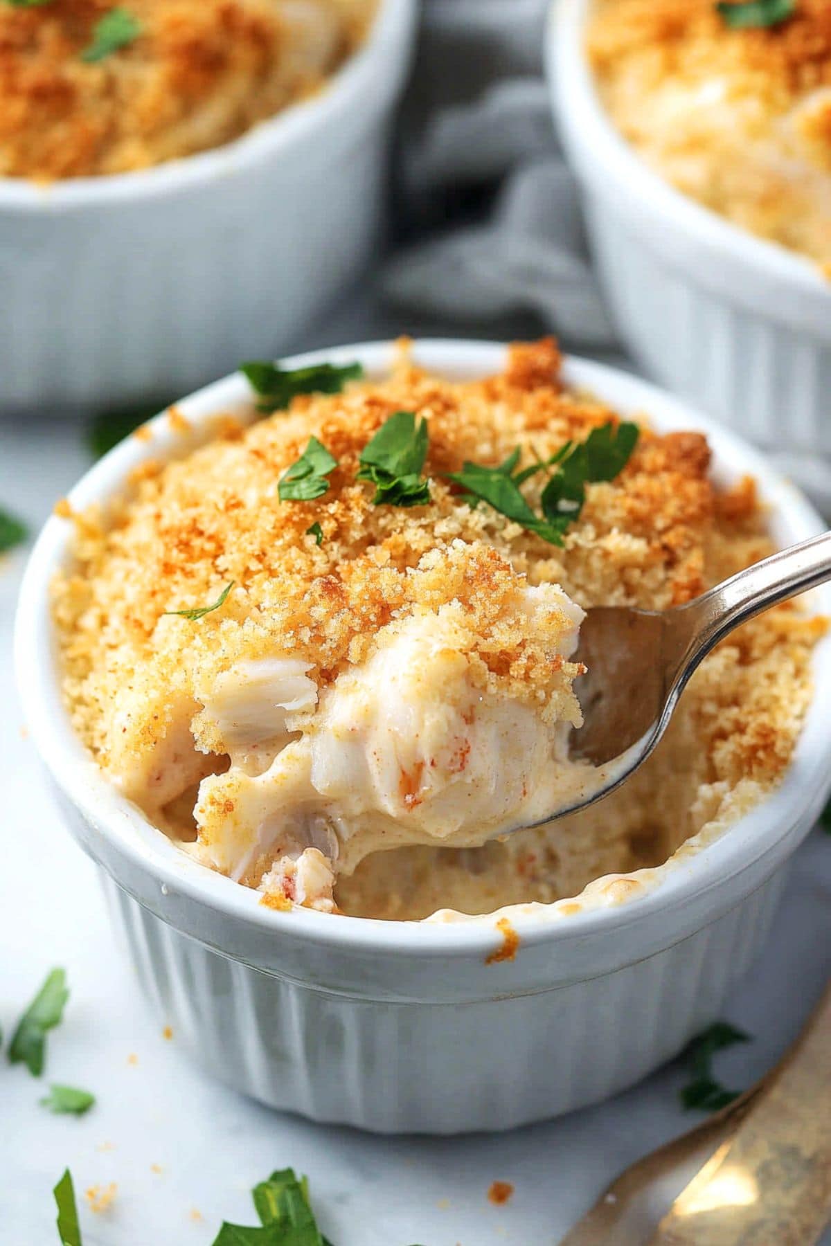 Crabmeat baked in creamy sauce covered with breadcrumbs in a ramekin dish.