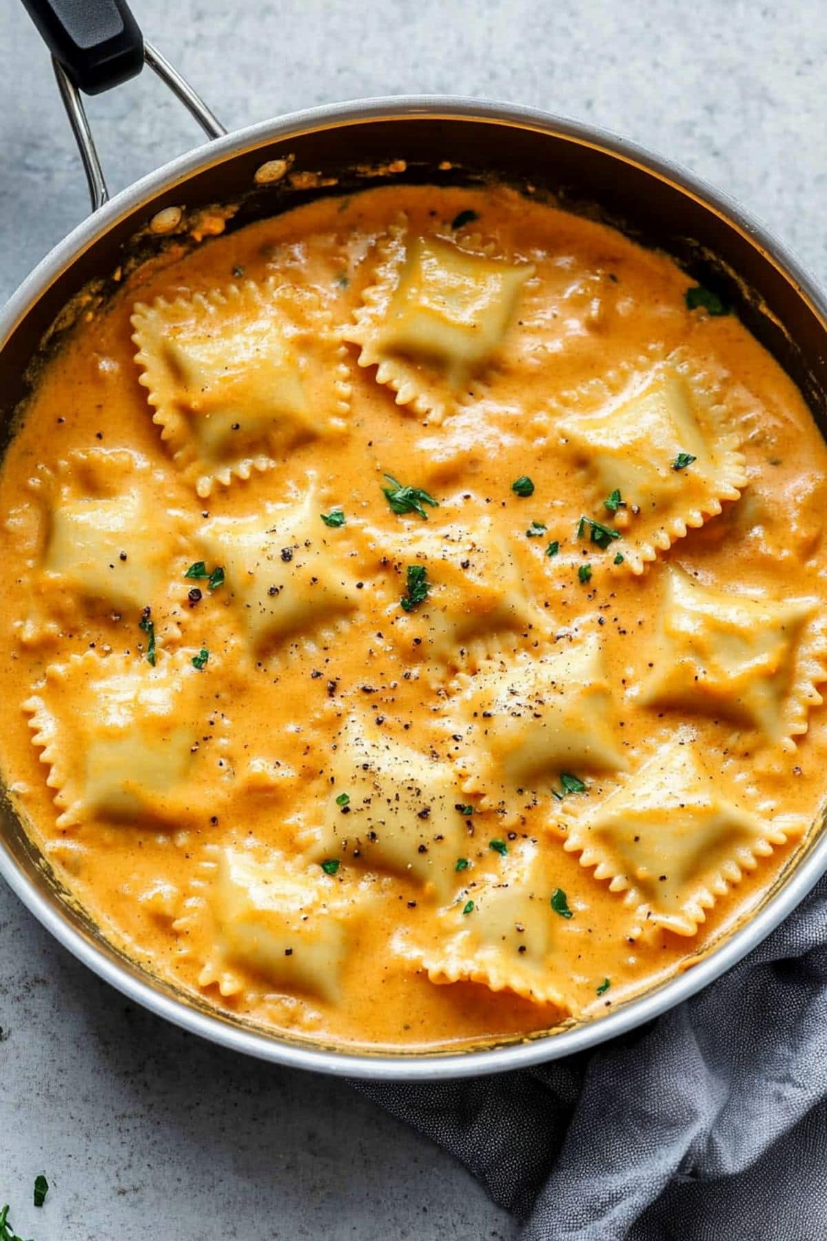 Ravioli pasta with creamy and cheesy pumpkin sauce  in a skillet pan.