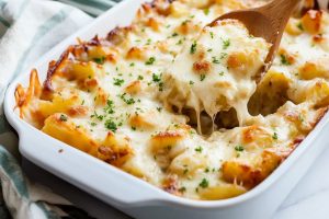 Baked potatoes with cheesy and creamy french onion potatoes in a baking dish.